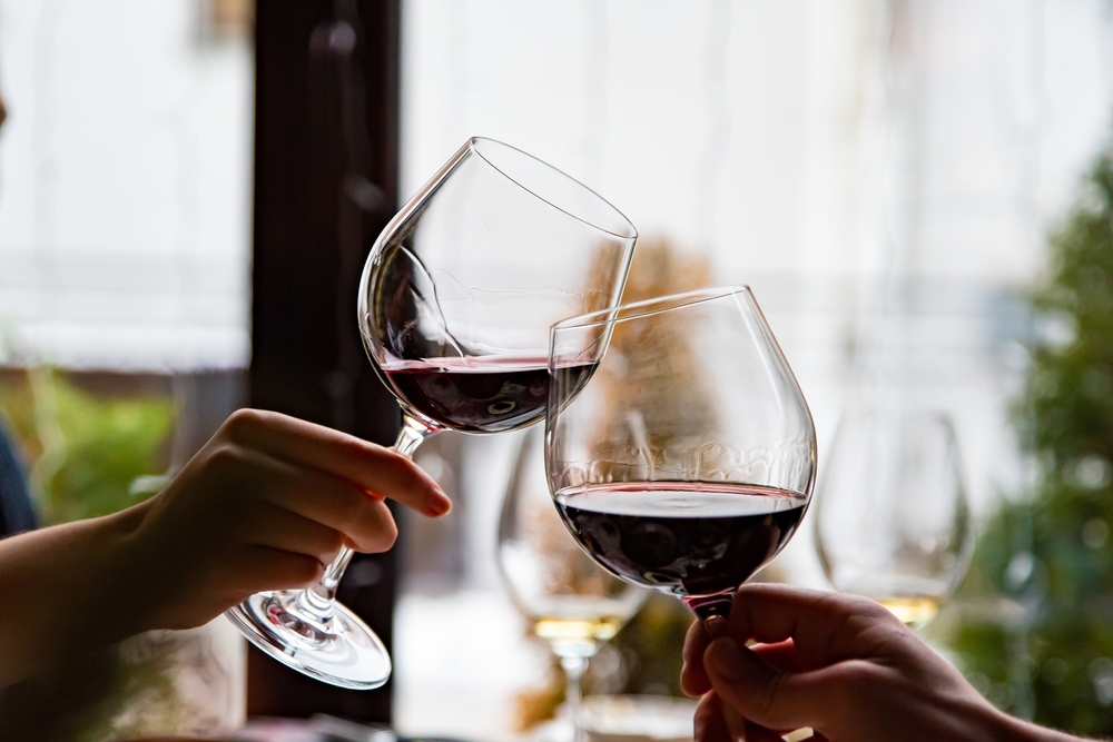 Closeup of a couple toasting with red wine while dining at Hood River Restaurants in Oregon