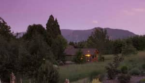 A purple sky at dusk serves as a sweet backdrop behind the Green Leaf cabin at Carson Ridge Luxury Cabins in Washington.
