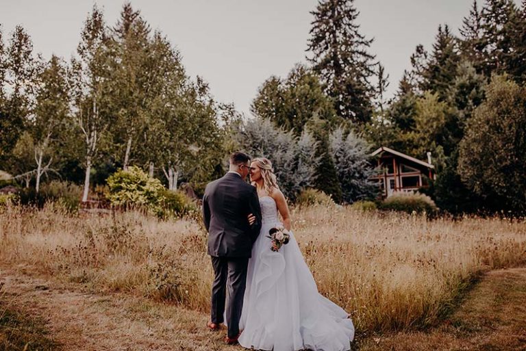 Stunning couple getting married in front of the cabins at our small wedding venues in Washington State