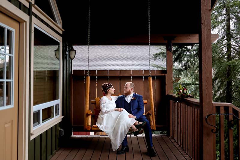 A romantic couple on the porch swing at our luxury cabins during their elopement in Washington State