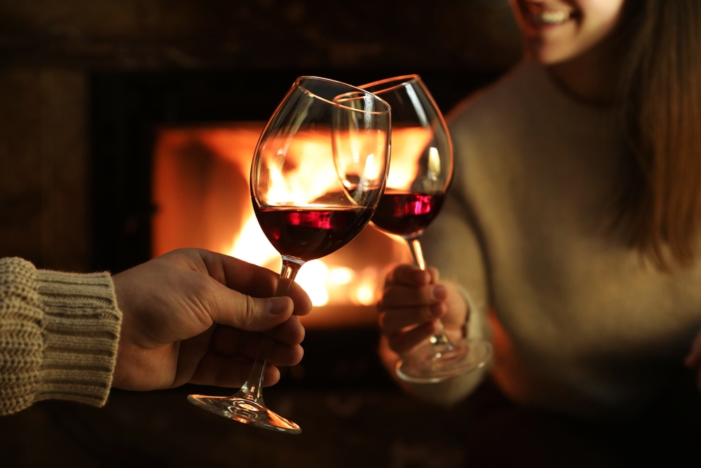 Couple unwinding with a glass of wine in front of the fire during romantic weekend getaways in Washington